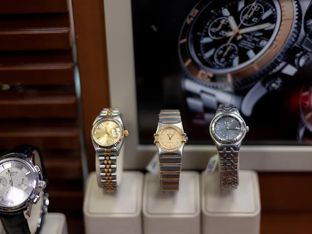 Auslage von hochwertigen Armbanduhren beim Juwelier, drei verschiedene Modelle auf Uhrenständern